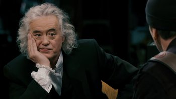 Movie still from “It Might Get Loud” (2008), directed by Davis Guggenheim – An older man in a black suit and white shirt; Close Up shot, Over the shoulder angle