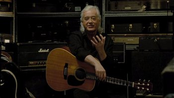 Movie still from “It Might Get Loud” (2008), directed by Davis Guggenheim – An older man sitting in front of an acoustic guitar; Medium shot, Over the shoulder angle
