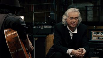 Movie still from “It Might Get Loud” (2008), directed by Davis Guggenheim – An older man sitting in front of an electric guitar; Medium shot, Over the shoulder angle