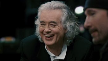 Movie still from “It Might Get Loud” (2008), directed by Davis Guggenheim – An older man with white curly hair smiling; Close Up shot, High angle