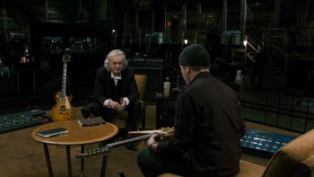Movie still from “It Might Get Loud” (2008), directed by Davis Guggenheim – Two men sitting in a room with a guitar; Medium shot, Over the shoulder angle