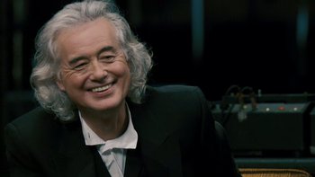 Movie still from “It Might Get Loud” (2008), directed by Davis Guggenheim – An older man with white hair smiling for the camera; Close Up shot, Over the shoulder angle