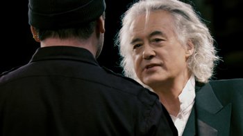 Movie still from “It Might Get Loud” (2008), directed by Davis Guggenheim – A man in a black shirt is talking to another man in a white shirt; Close Up shot, Over the shoulder angle