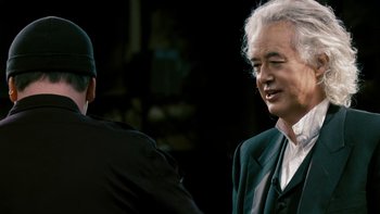 Movie still from “It Might Get Loud” (2008), directed by Davis Guggenheim – A man in a black suit and a man in a green suit; Close Up shot, Over the shoulder angle