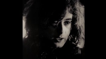Movie still from “It Might Get Loud” (2008), directed by Davis Guggenheim – A person with long curly hair; Close Up shot, High angle