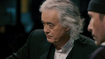 Movie still from “It Might Get Loud” (2008), directed by Davis Guggenheim – An older man in a black suit and white shirt looking to his left; Close Up shot, High angle