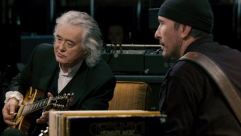 Movie still from “It Might Get Loud” (2008), directed by Davis Guggenheim – A man sitting next to another man holding a guitar; Close Up shot, Over the shoulder angle