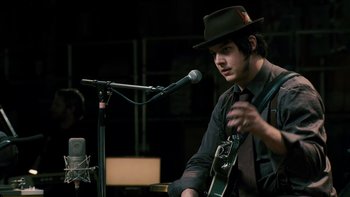 Movie still from “It Might Get Loud” (2008), directed by Davis Guggenheim – A man in a black hat is playing a guitar; Close Up shot, Over the shoulder angle