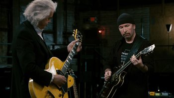 Movie still from “It Might Get Loud” (2008), directed by Davis Guggenheim – A man and a woman are playing a guitar duet; Medium shot, Low angle