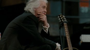 Movie still from “It Might Get Loud” (2008), directed by Davis Guggenheim – An older man sitting next to an electric guitar; Close Up shot, Low angle