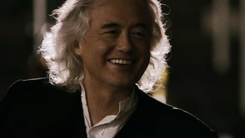Movie still from “It Might Get Loud” (2008), directed by Davis Guggenheim – An older man with long white hair smiling for the camera; Close Up shot, Low angle