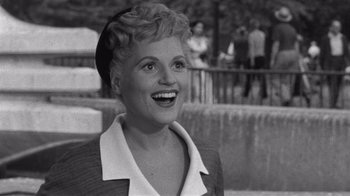 Movie still from “It Should Happen to You” (1954), directed by George Cukor – An old black and white photo of a woman smiling; Close Up shot, High angle