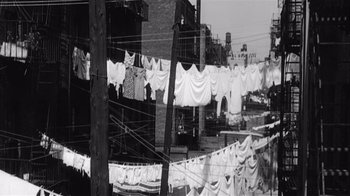 Movie still from “It Should Happen to You” (1954), directed by George Cukor – A black and white photo of clothes hanging on a clothesline; Wide shot, High angle