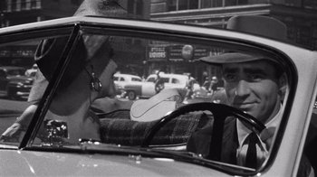 Movie still from “It Should Happen to You” (1954), directed by George Cukor – A man and a woman in the backseat of a car; Close Up shot, Over the shoulder angle