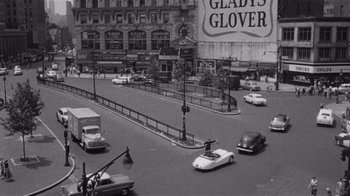 Movie still from “It Should Happen to You” (1954), directed by George Cukor – A black and white photo of cars on a city street; Extreme Wide shot, High angle