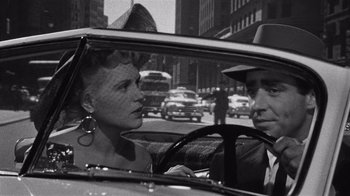 Movie still from “It Should Happen to You” (1954), directed by George Cukor – A man and a woman in the backseat of a car; Close Up shot, Over the shoulder angle