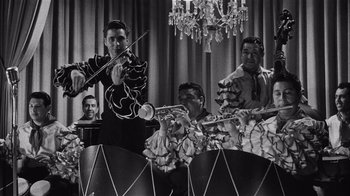 Movie still from “It Should Happen to You” (1954), directed by George Cukor – A black and white photo of men playing musical instruments; Medium shot, Low angle