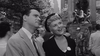 Movie still from “It Should Happen to You” (1954), directed by George Cukor – An old photo of a man and a woman; Medium shot, Low angle
