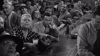 Movie still from “It Should Happen to You” (1954), directed by George Cukor – A group of people sitting at a bar with drinks; Medium shot, High angle