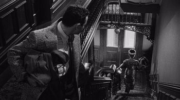 Movie still from “It Should Happen to You” (1954), directed by George Cukor – A man and a woman walking down a staircase; Medium shot, Low angle