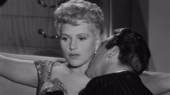 Movie still from “It Should Happen to You” (1954), directed by George Cukor – An old photo of a man kissing a woman on the cheek; Close Up shot, High angle