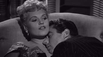 Movie still from “It Should Happen to You” (1954), directed by George Cukor – An old photo of a man and a woman laying on a couch; Close Up shot, High angle