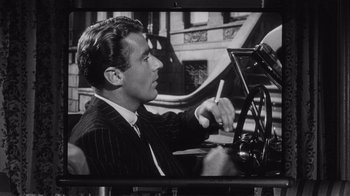 Movie still from “It Should Happen to You” (1954), directed by George Cukor – A black and white photo of a man sitting at a desk; Close Up shot, Over the shoulder angle