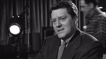 Movie still from “It Should Happen to You” (1954), directed by George Cukor – An older man in a suit and tie; Close Up shot, Over the shoulder angle