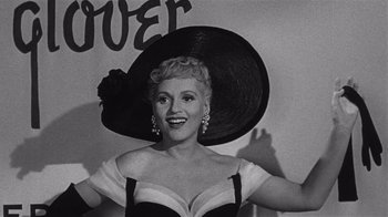 Movie still from “It Should Happen to You” (1954), directed by George Cukor – An old black and white photo of a woman wearing a hat; Close Up shot, Low angle