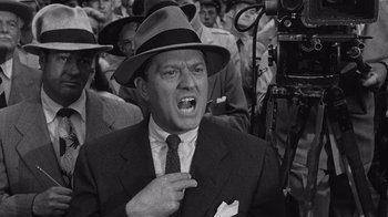 Movie still from “It Should Happen to You” (1954), directed by George Cukor – An old photo of a man in a suit and a hat; Close Up shot, Low angle