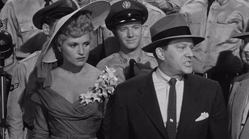 Movie still from “It Should Happen to You” (1954), directed by George Cukor – A group of people standing next to each other in a crowd; Medium shot, Over the shoulder angle
