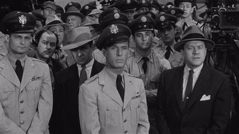 Movie still from “It Should Happen to You” (1954), directed by George Cukor – Black and white photograph of a group of men in uniform; Medium shot, Low angle