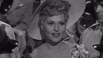 Movie still from “It Should Happen to You” (1954), directed by George Cukor – An old black and white photo of a woman with a hat; Close Up shot, Over the shoulder angle