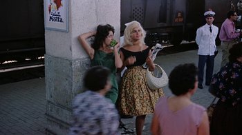 Movie still from “It Started in Naples” (1960), directed by Melville Shavelson – Two women standing next to each other on the sidewalk; Wide shot, Low angle