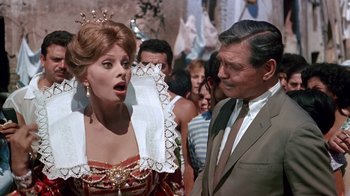 Movie still from “It Started in Naples” (1960), directed by Melville Shavelson – A man and a woman are standing next to each other in front of a crowd; Medium shot, Over the shoulder angle