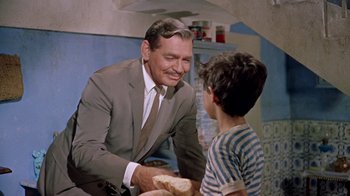 Movie still from “It Started in Naples” (1960), directed by Melville Shavelson – An older man and a young boy holding a piece of bread; Medium shot, Over the shoulder angle