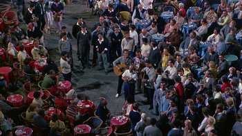 Movie still from “It Started in Naples” (1960), directed by Melville Shavelson – A group of people standing around a street; Wide shot, High angle