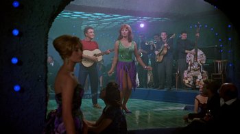 Movie still from “It Started in Naples” (1960), directed by Melville Shavelson – A group of people standing in front of a stage; Wide shot, High angle