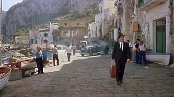 Movie still from “It Started in Naples” (1960), directed by Melville Shavelson – A man walking down a street holding a suitcase; Wide shot, High angle