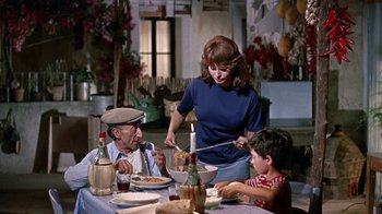 Movie still from “It Started in Naples” (1960), directed by Melville Shavelson – An old man and a young boy sitting at a dinner table; Medium shot, High angle