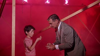 Movie still from “It Started in Naples” (1960), directed by Melville Shavelson – An older man and a young boy in a red room; Medium shot, Over the shoulder angle