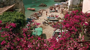 Movie still from “It Started in Naples” (1960), directed by Melville Shavelson – A bunch of people on a beach with boats and pink flowers; Extreme Wide shot, High angle