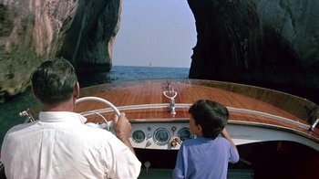 Movie still from “It Started in Naples” (1960), directed by Melville Shavelson – A man and a child on a boat in the water; Wide shot, High angle