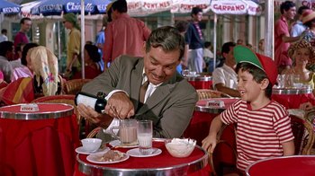 Movie still from “It Started in Naples” (1960), directed by Melville Shavelson – A man and a child at an outdoor cafe; Medium shot, Over the shoulder angle