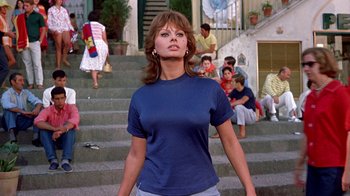 Movie still from “It Started in Naples” (1960), directed by Melville Shavelson – A woman standing on some steps in front of some people; Medium shot, Low angle