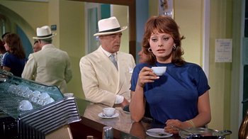 Movie still from “It Started in Naples” (1960), directed by Melville Shavelson – A man and a woman sitting at a table with a cup of coffee; Medium shot, Over the shoulder angle