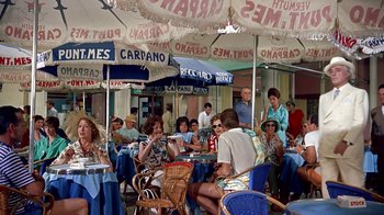 Movie still from “It Started in Naples” (1960), directed by Melville Shavelson – A group of people sitting at tables under umbrellas at an outdoor cafe; Wide shot, High angle