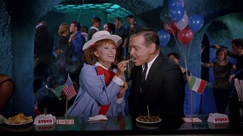 Movie still from “It Started in Naples” (1960), directed by Melville Shavelson – An older man and woman are eating at a party; Medium shot, High angle