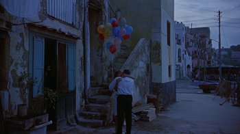 Movie still from “It Started in Naples” (1960), directed by Melville Shavelson – A man and a woman standing in front of a building with a bunch of balloons; Wide shot, Low angle
