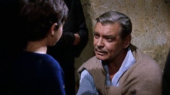 Movie still from “It Started in Naples” (1960), directed by Melville Shavelson – An older man talking to a young boy in front of a stone wall; Close Up shot, Over the shoulder angle